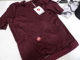 maroon jacket with a red badge on it sitting on a white table