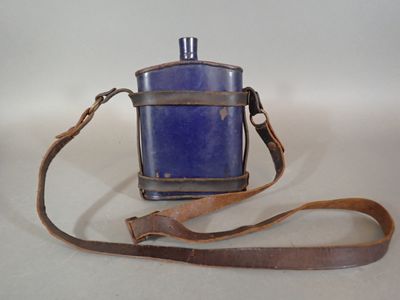 a small blue bottle with a brown strap on it