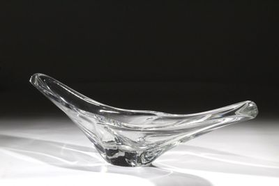 un saladier en verre posé sur une table, sur fond noir