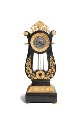 Pendule en forme d’un lyre en chêne plaqué d’ébène. Avec son…