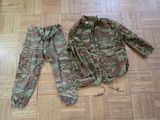 a camouflage jacket and pants sitting on the floor