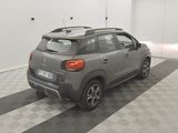 the rear end of a grey car parked in a garage