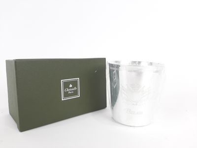 the silver cup is next to a green box on a white surface