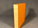 an orange book sitting on top of a table next to a black table