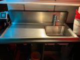 a sink in a small kitchen with a red light