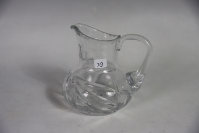 a clear glass pitcher with a handle on a table