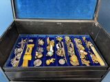 a black box filled with lots of gold and silver brooches