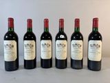 six bouteilles de vin sont alignées sur une table