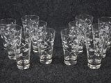 six verres en verre gravé sont alignés sur une surface noire