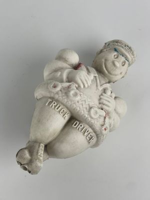 une petite figurine représentant un homme tenant un bébé dans ses bras