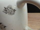 a white coffee pot sitting on top of a wooden table