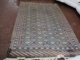 un tapis posé à même le sol, à côté de coussins posés à même le sol