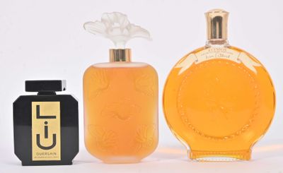 trois flacons de parfum posés l'un à côté de l'autre sur une surface blanche