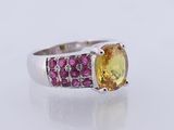 a yellow sapphire and pink tourmaline ring on a white surface