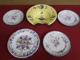 five plates and a bowl sitting on a red table