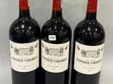 trois bouteilles de vin rouge sont alignées sur une table