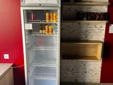 une photo d'un réfrigérateur dans une cuisine dont le mur est rouge