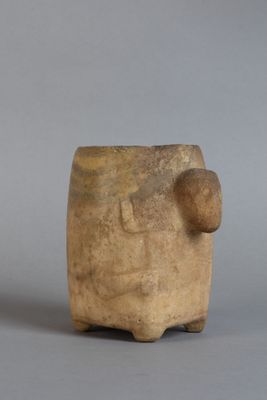 un petit vase marron surmonté d'une boule