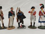 three figurines of men dressed in uniforms of different ages