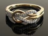 une image d'une bague en or et en diamant sur une surface noire