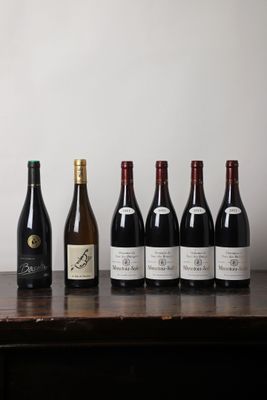 des bouteilles de vin alignées sur une table en bois devant un mur blanc
