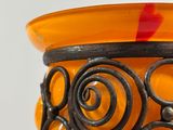 an orange vase with black swirly designs on it