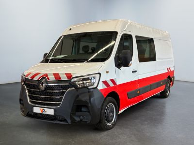 La camionnette blanche est garée dans une pièce ornée d'une bande rouge et blanche.