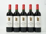 quatre bouteilles de vin rouge sont alignées sur une table