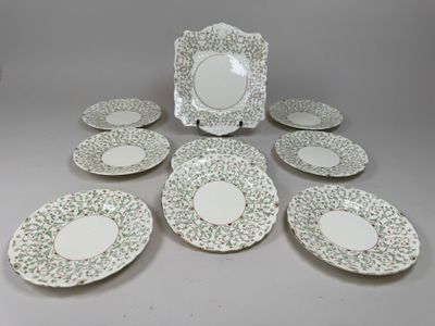 six assiettes blanches et vertes et un cadre photo posés sur une table