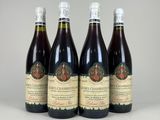 quatre bouteilles de vin posées sur une table blanche