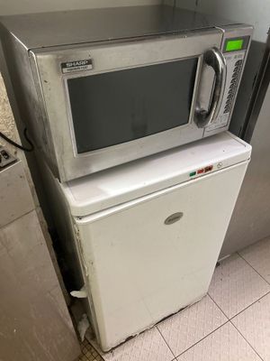 un micro-ondes posé sur un réfrigérateur dans une cuisine