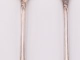 two spoons and a fork on a white table