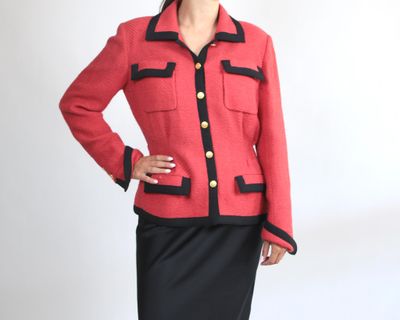 une femme vêtue d'une veste rouge et d'une jupe noire qui pose pour une photo