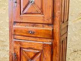 an old wooden cabinet sitting on top of a tiled floor