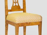 une image représentant une chaise en bois dont l'assise est recouverte d'un tissu jaune