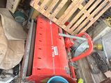a pile of junk in a garage with a red fire hydrant next to it
