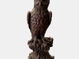 an image of a statue of an owl sitting on a tree stump