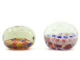 two glass beads are sitting next to each other on a white surface