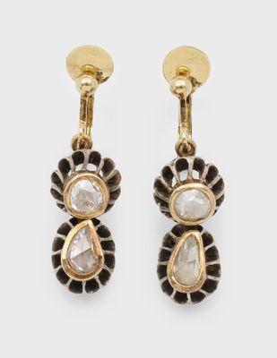 une paire de boucles d'oreilles dorées ornées de pierres blanches et noires