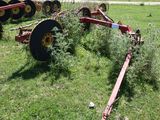 a tractor that is sitting in the grass with a plow