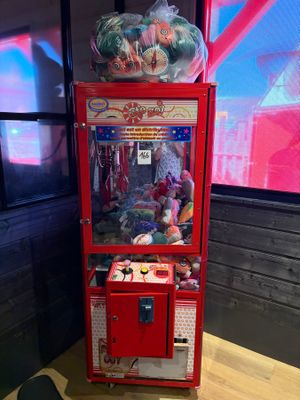 un distributeur automatique rouge posé sur une table en bois