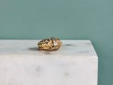 un gros plan d'une bague en or posée sur un bloc de marbre