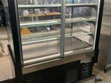 a refrigerated display case in the middle of a room
