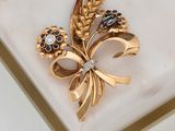 a gold brooch with black and white stones on it