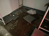 debris on the floor of a bathroom with a toilet in the corner
