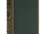 un vieux livre à la couverture verte et aux bordures dorées