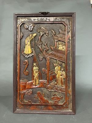 une photo représentant une plaque en bois sur laquelle figurent des personnes dans un jardin