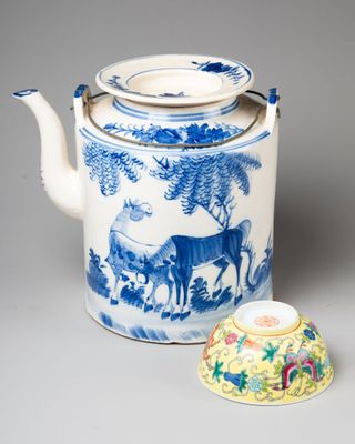 une théière bleue et blanche avec un couvercle et une tasse