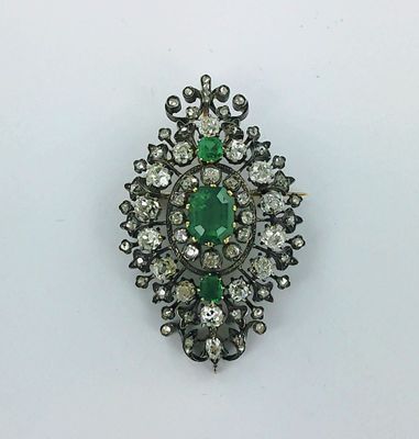 un gros plan d'une broche verte et blanche posée sur une surface blanche