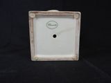 a close up of a small white clock on a black background